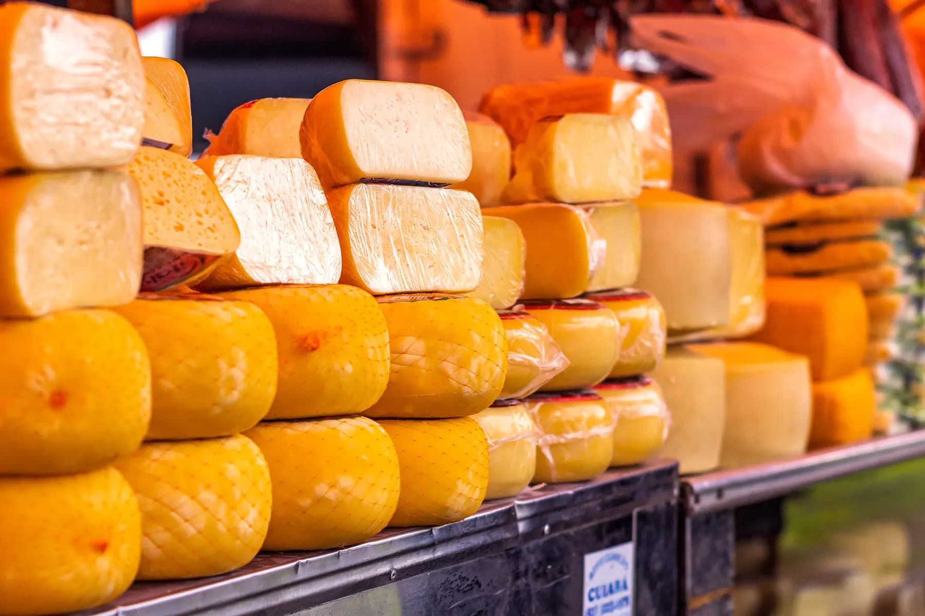 Stacked wheels of cheese at a market stall